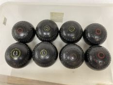 Eight lawn green bowling balls