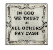 Cast iron 'In God we Trust' sign with black writing on a white ground