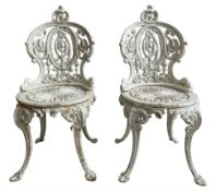 Pair of Victorian white painted cast iron garden chairs