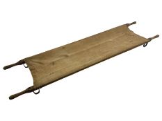 WW1 British casualty stretcher with iron mounted pitch pine sides and canvas base; stamped 'HL1917'