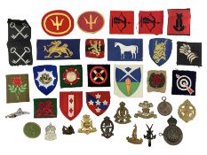 Thirty-six British metal and cloth badges including RAOC