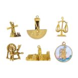 Six 9ct gold pendant/charms including spinning wheel