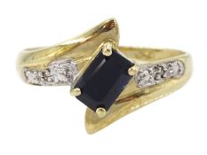 9ct gold emerald cut blue/black stone and diamond cross over ring