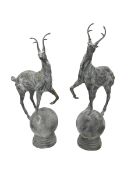Pair of cast iron garden stag finials atop a sphere base