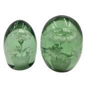 Two Victorian green glass dump paperweights with interior flower decoration