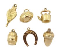 Six 9ct gold charms including acorn