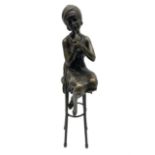 Art Deco style bronze figure of a lady seated on a stool applying lipstick