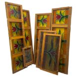 Collection of leaded stained glass window panes in mahogany frames