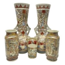 Pair of Japanese Satsuma vases decorated with four panels of figures in a landscape setting between