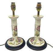 Pair of Moorcroft table lamps of candlestick form in magnolia pattern