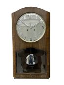 A mid 20th century German wall clock in a veneered mahogany case with a German eight day 'Kienzle' m