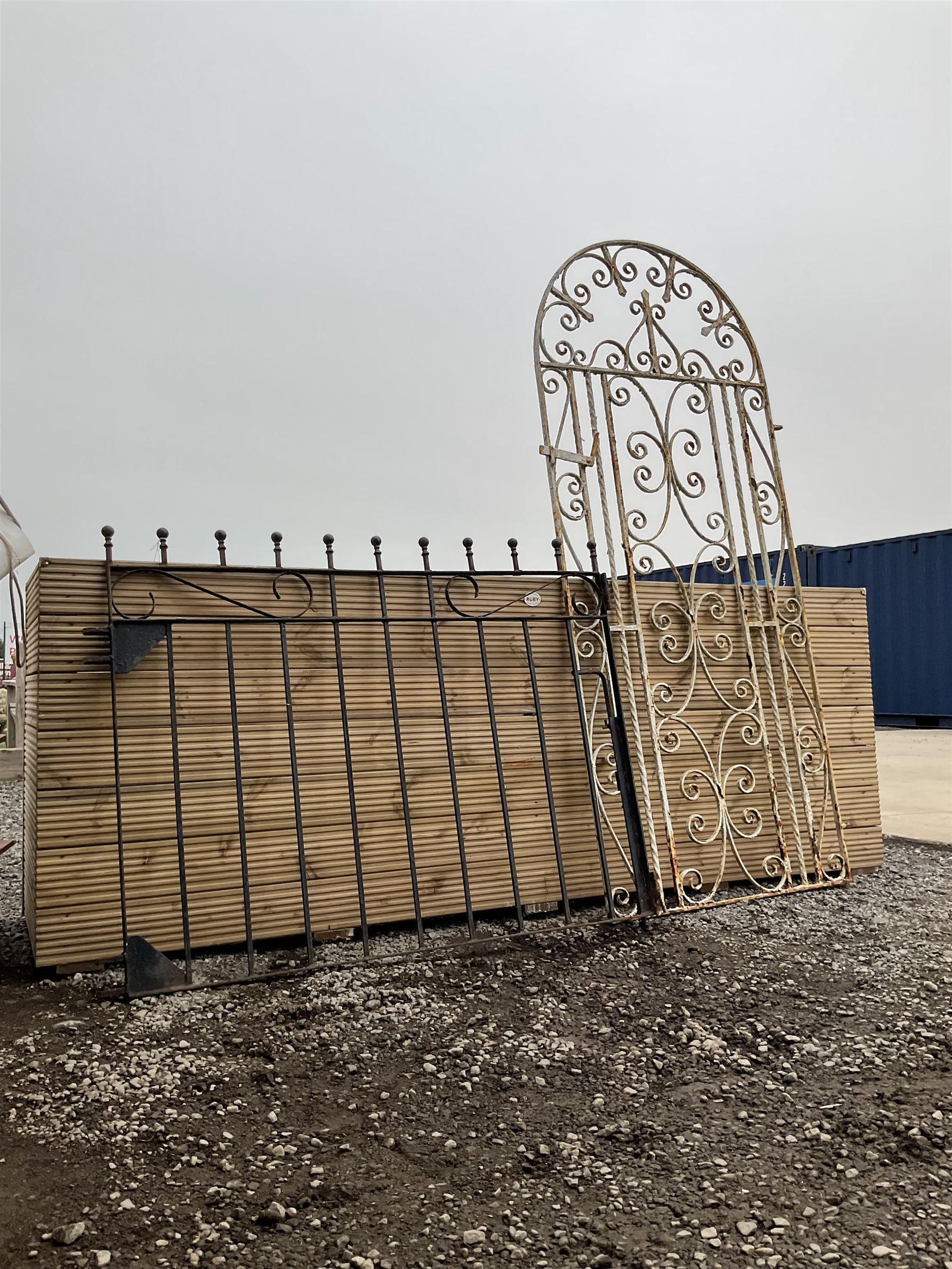 Two wrought iron garden gates painted in black and white