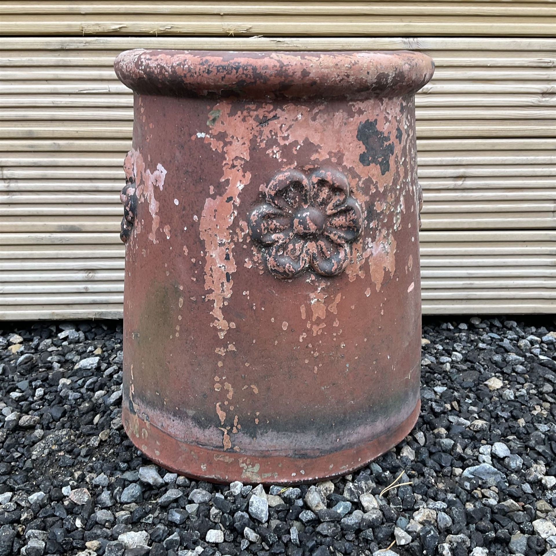 Terracotta chimney pot decorated with rose head motifs