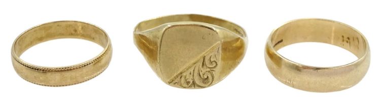 Two gold wedding bands and a gold signet ring