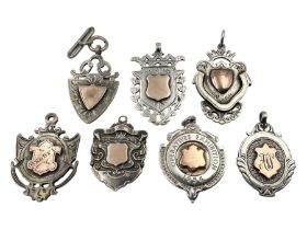 Seven early 20th century silver gold faced cartouche fobs