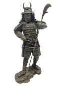 Bronze figure of a samurai standing wearing armour and holding a naginata