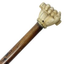 19th century malacca walking cane with scrimshaw handled in the form of a clenched fist holding a sc