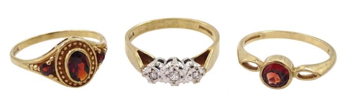 Two gold garnet rings and a gold three stone diamond ring