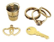 Four 9ct gold pendant / charms including champagne bottle and bucket