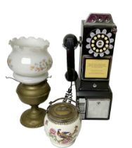 Wall mounting pay phone; oil lamp with shade; and biscuit barrel