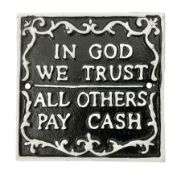Cast iron 'In God we Trust' sign with white writing on a black ground