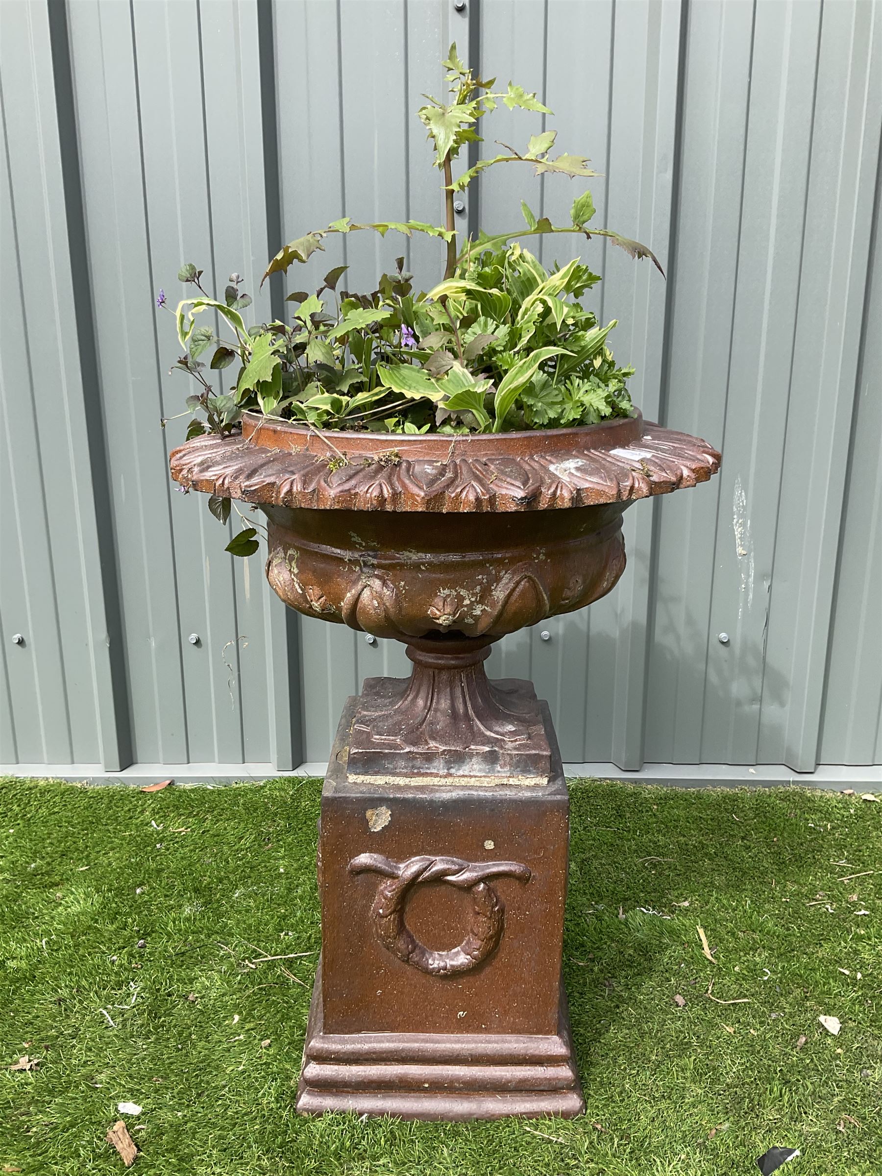 Terracotta garden urn on plinth