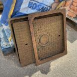 Two cast iron manhole drain covers with surrounds