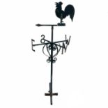 A wrought iron weather vane with cockerel decoration.