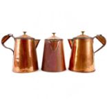 A set of three copper jugs and covers with brass finials.