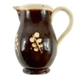 An early 19th century English pottery sparrow beak jug in a treacle glaze.