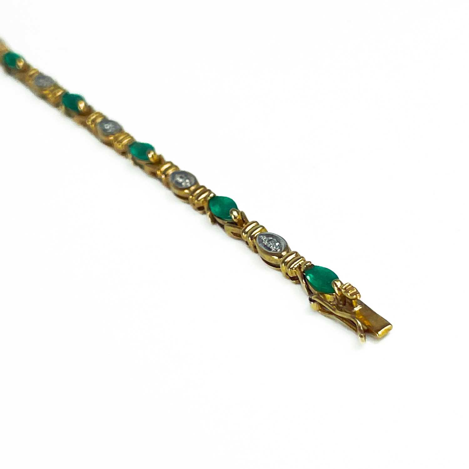 A modern 9ct gold diamond and emerald set bracelet. - Image 9 of 10