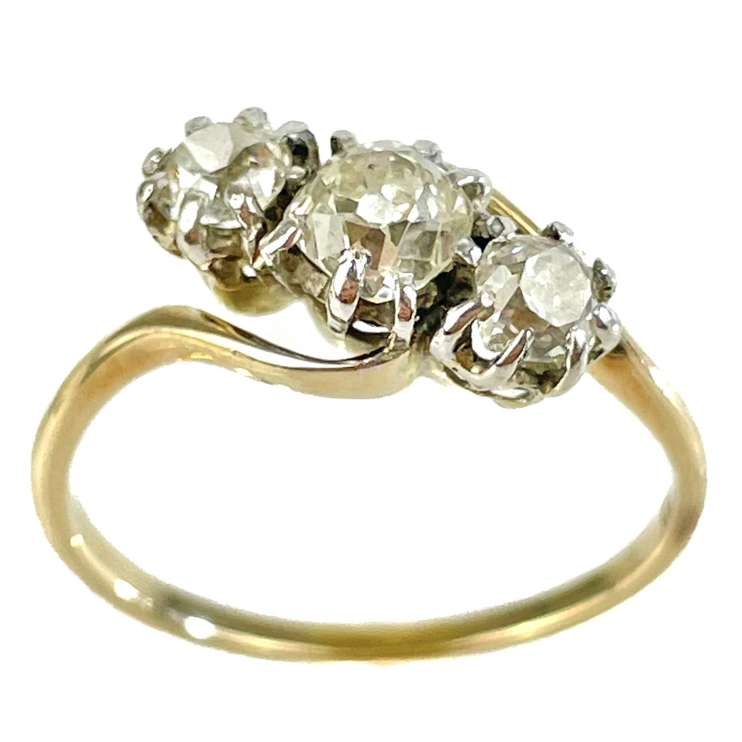 An early 20th century 18ct gold diamond set three stone crossover ring.