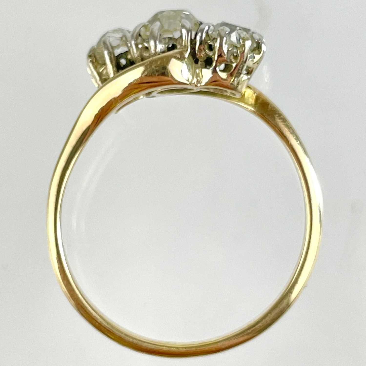 An early 20th century 18ct gold diamond set three stone crossover ring. - Image 5 of 5