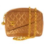 A Chanel gold quilted leather turn lock camera bag.