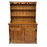 An Arts and Crafts light oak dresser in two parts.