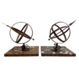 A pair of wrought iron and brass mounted armillary spheres.
