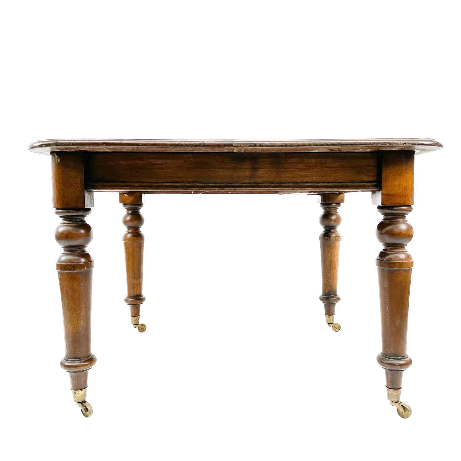 A late Victorian oak extending dining table.