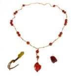 A Chinese amber bead necklace with two carved pendants.
