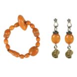 A butterscotch amber bead bracelet and a pair of Eastern white metal mounted pendant earrings.
