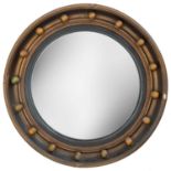 A gilt circular convex mirror.