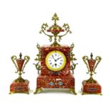 A French rouge marble, gilt metal and champleve enamel clock garniture.