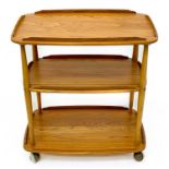 An Ercol Windsor light elm three tier trolley with lipped edges.