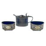 A silver three piece cruet set with blue glass liners.