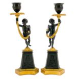 A pair of Regency style bronze and ormolu candlesticks.