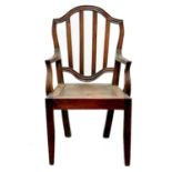A late George III country made elm commode chair.