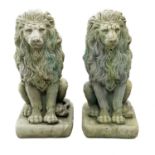 A pair of reconstituted stone lion figures.