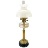 A Victorian brass oil lamp with a glass reservoir and white glass shade.