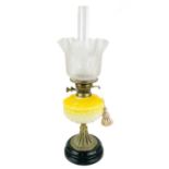A Victorian brass oil lamp with moulded yellow glass reservoir and etched glass shade.