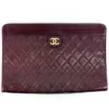 A Chanel burgundy quilted lambs leather clutch bag.