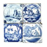 A group of four Delft blue and white tiles.